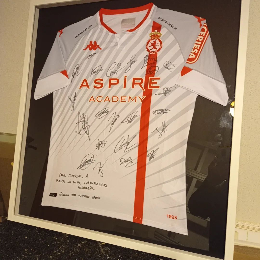 Una camisa blanca con la palabra Aspire Academy escrita en ella