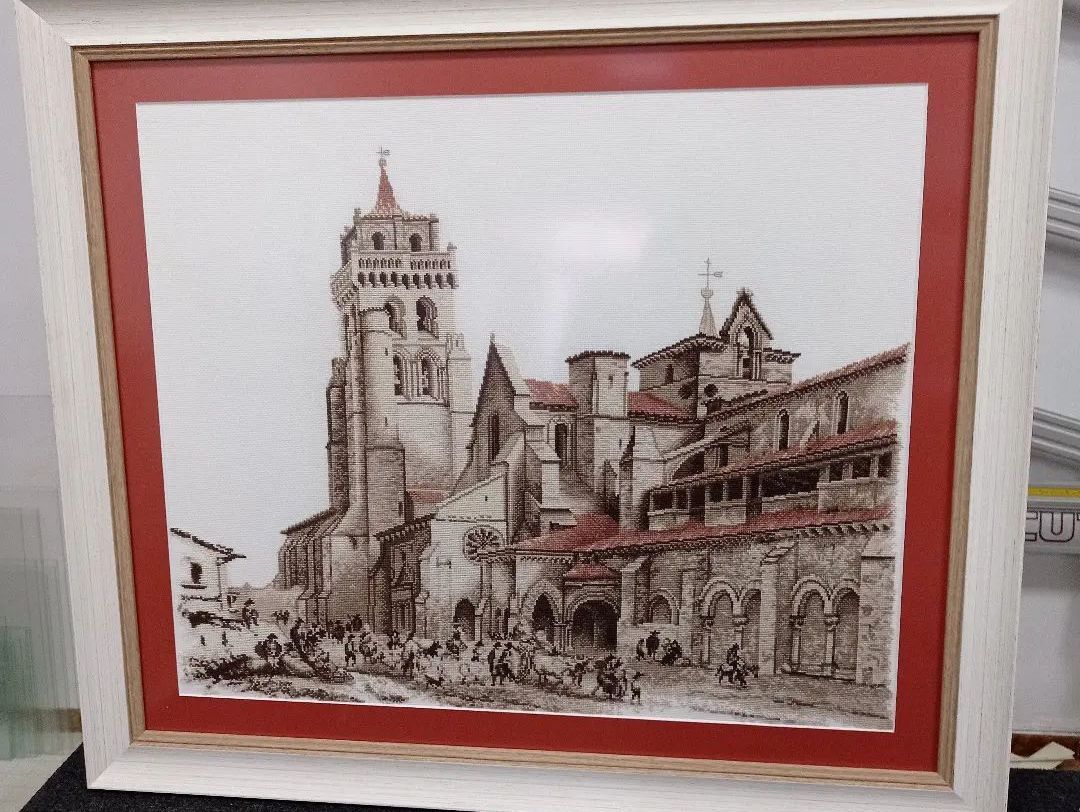 Un cuadro enmarcado de un castillo con un borde rojo.
