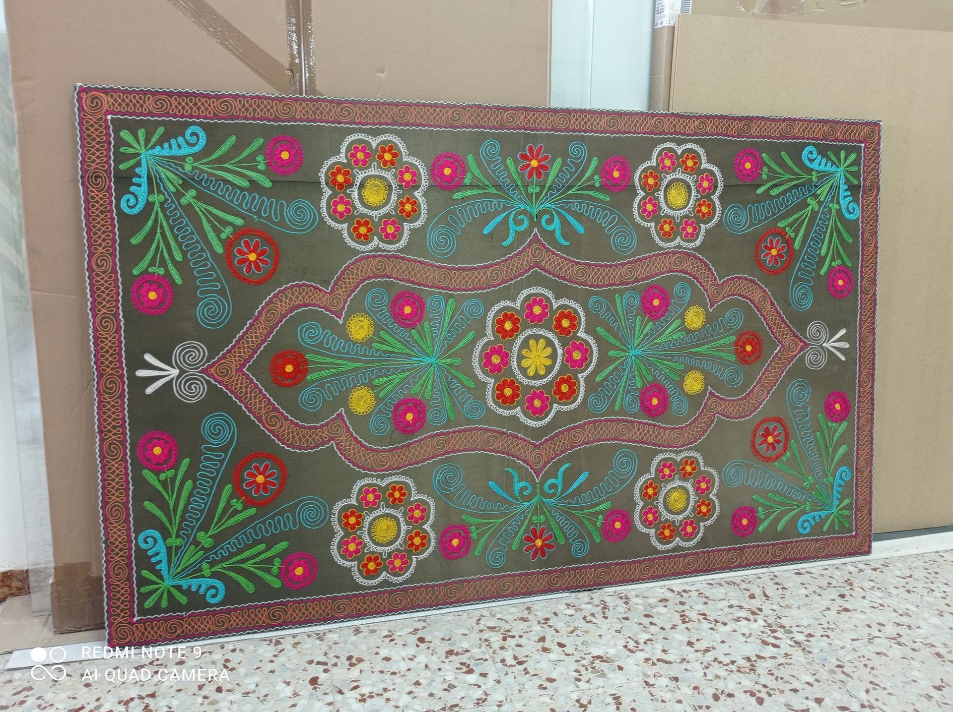 Una alfombra colorida con flores y hojas.