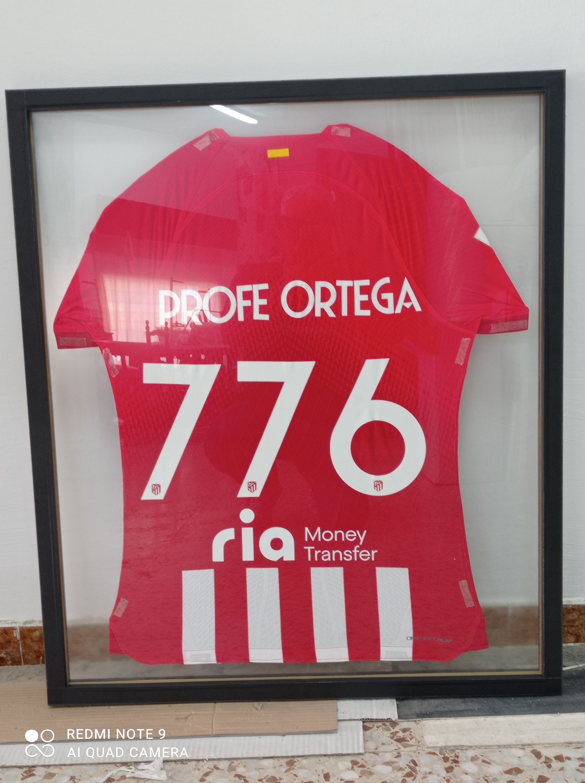 Una camiseta enmarcada con el nombre del profesor Ortega.