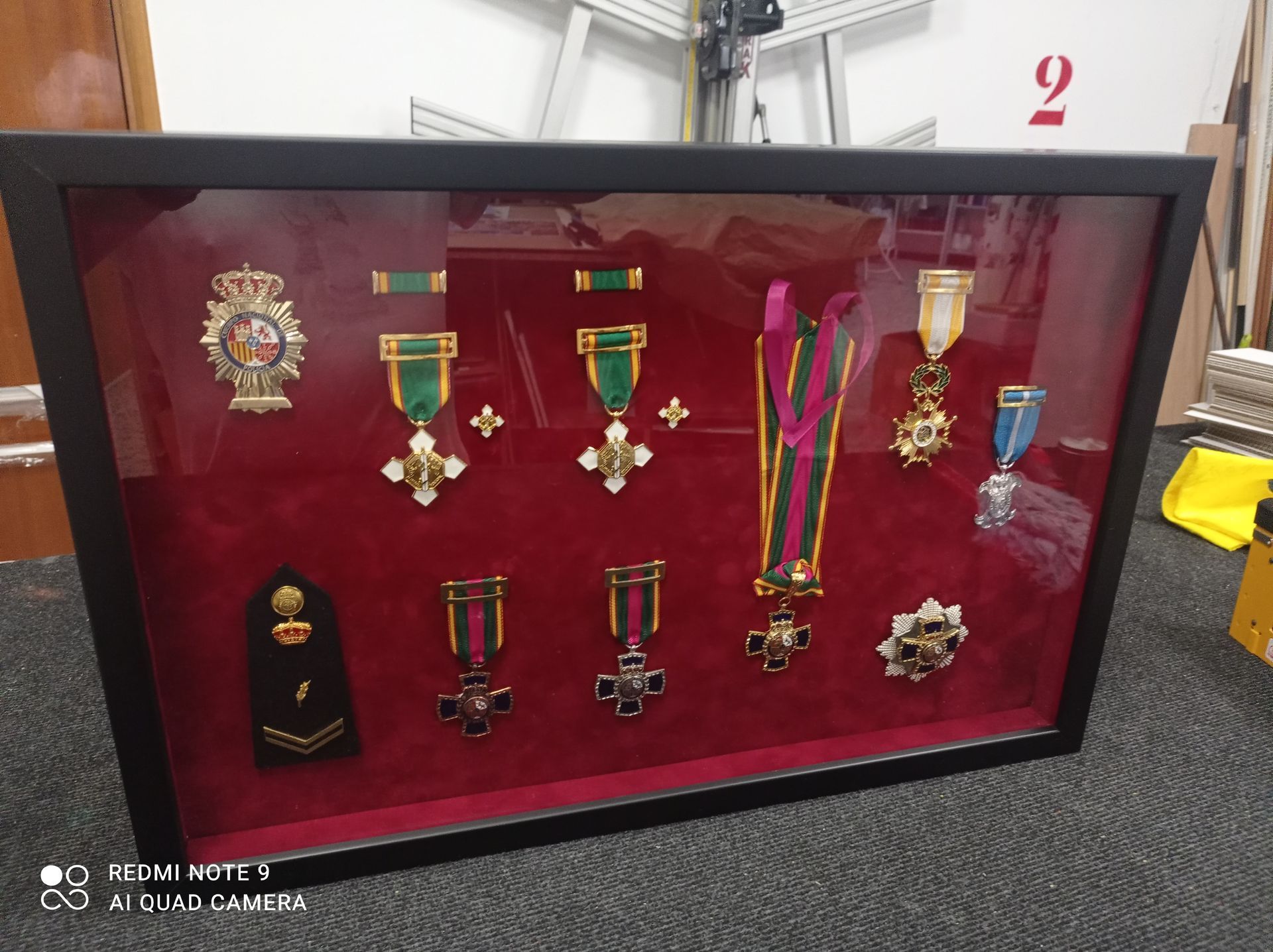 Una vitrina enmarcada llena de medallas e insignias