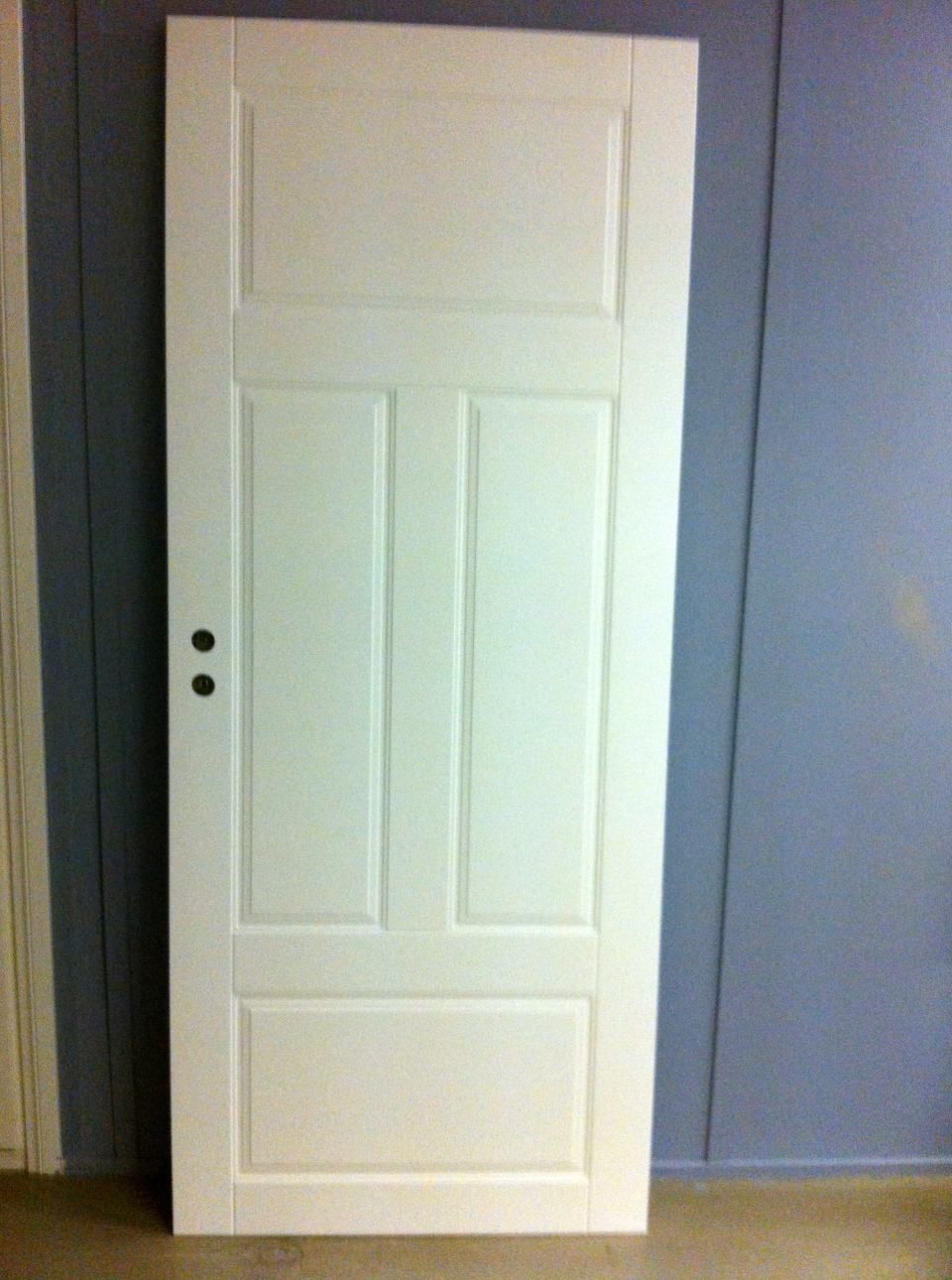 Valkoinen ovi kaiverruksilla