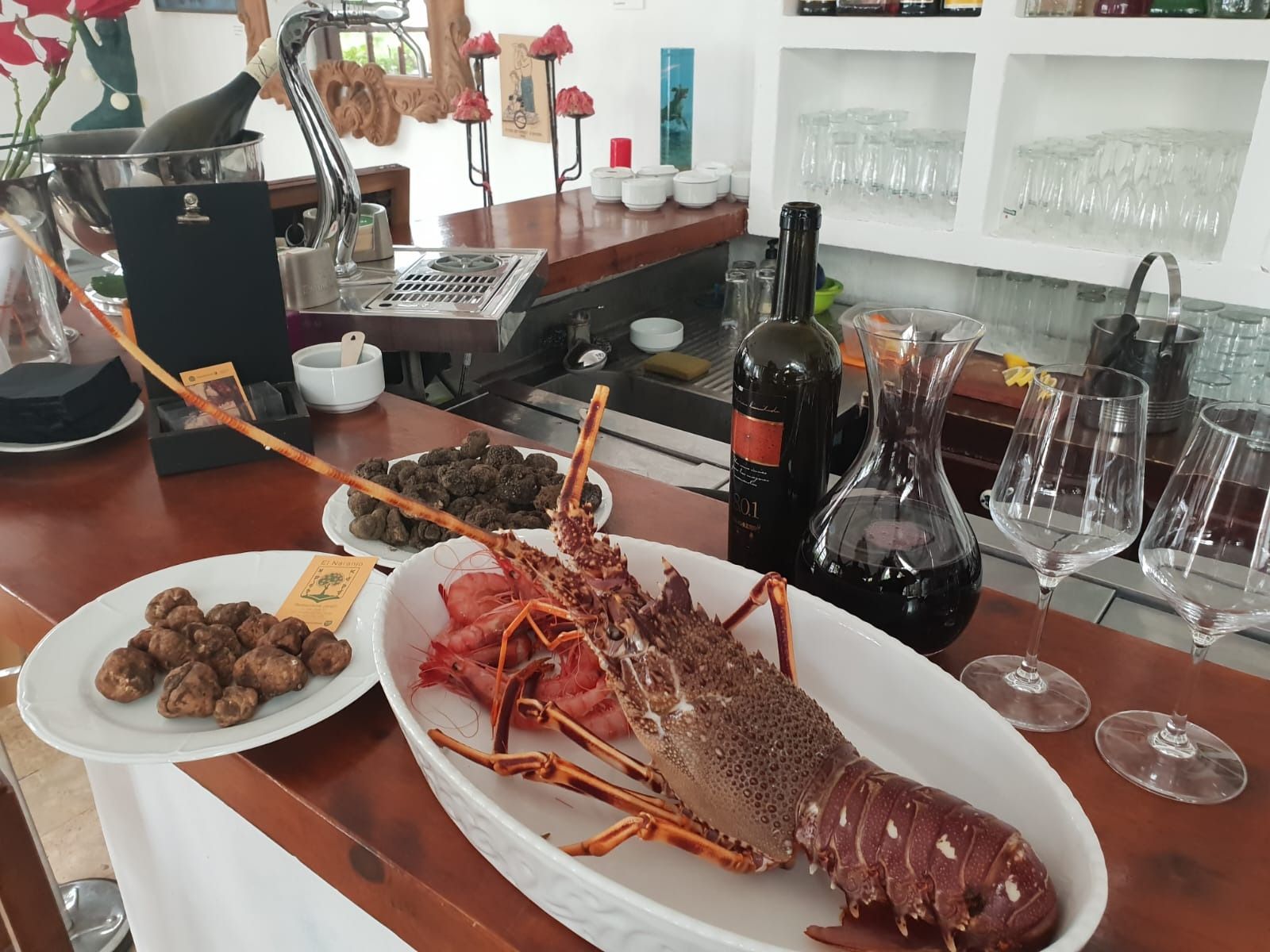 Una botella de vino reposa en una barra junto a un plato de comida.
