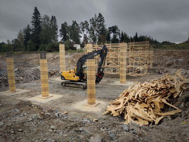 Moderni valkoinen talo mustilla yksityiskohdilla ja puisella terassilla, sininen taivas yläpuolella.