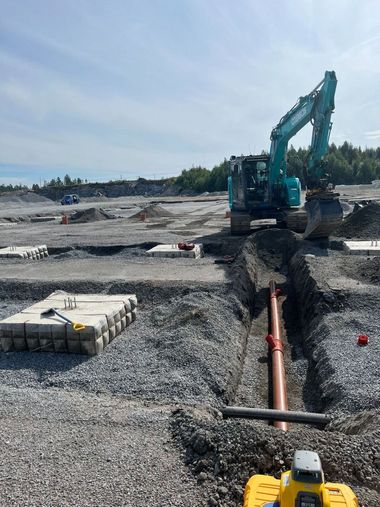 Moderni valkoinen talo mustilla yksityiskohdilla ja puisella terassilla, sininen taivas yläpuolella.