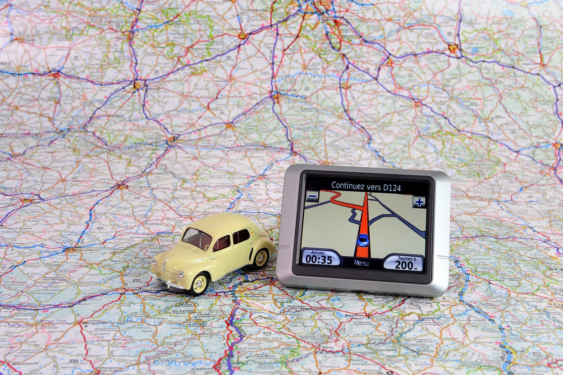 Voiture miniature et petit GPS sur une carte routière pliée