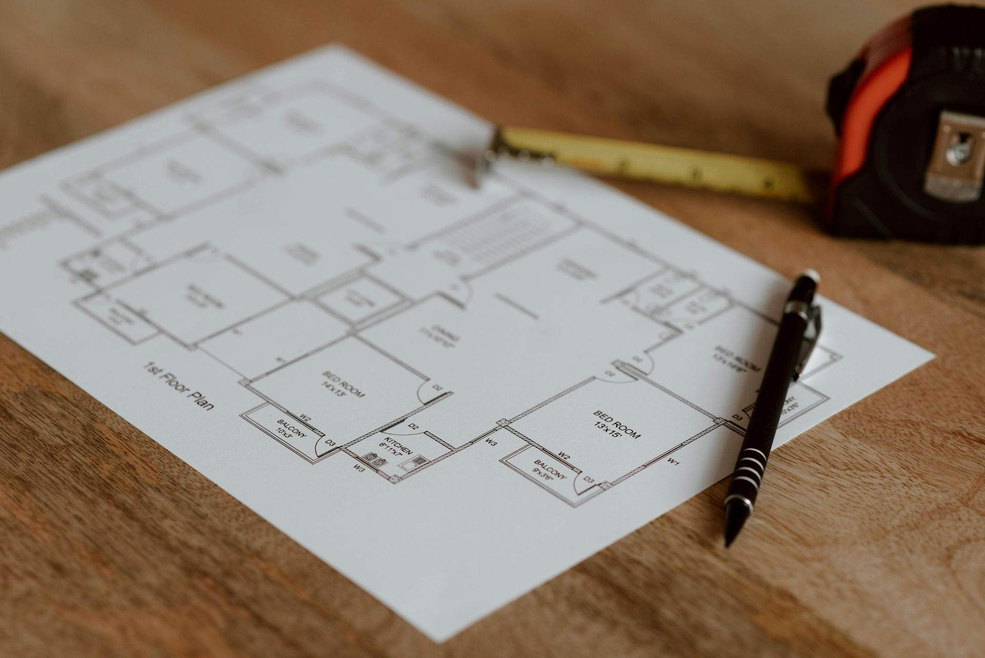 Zwei Personen arbeiten an einem Schreibtisch zusammen und zeigen auf Geschäftsdiagramme und Grafiken auf Papierdokumenten.