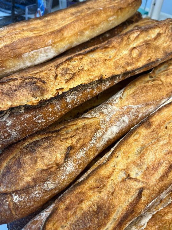 Gros plan sur plusieurs baguettes croustillantes empilées les unes sur les autres.