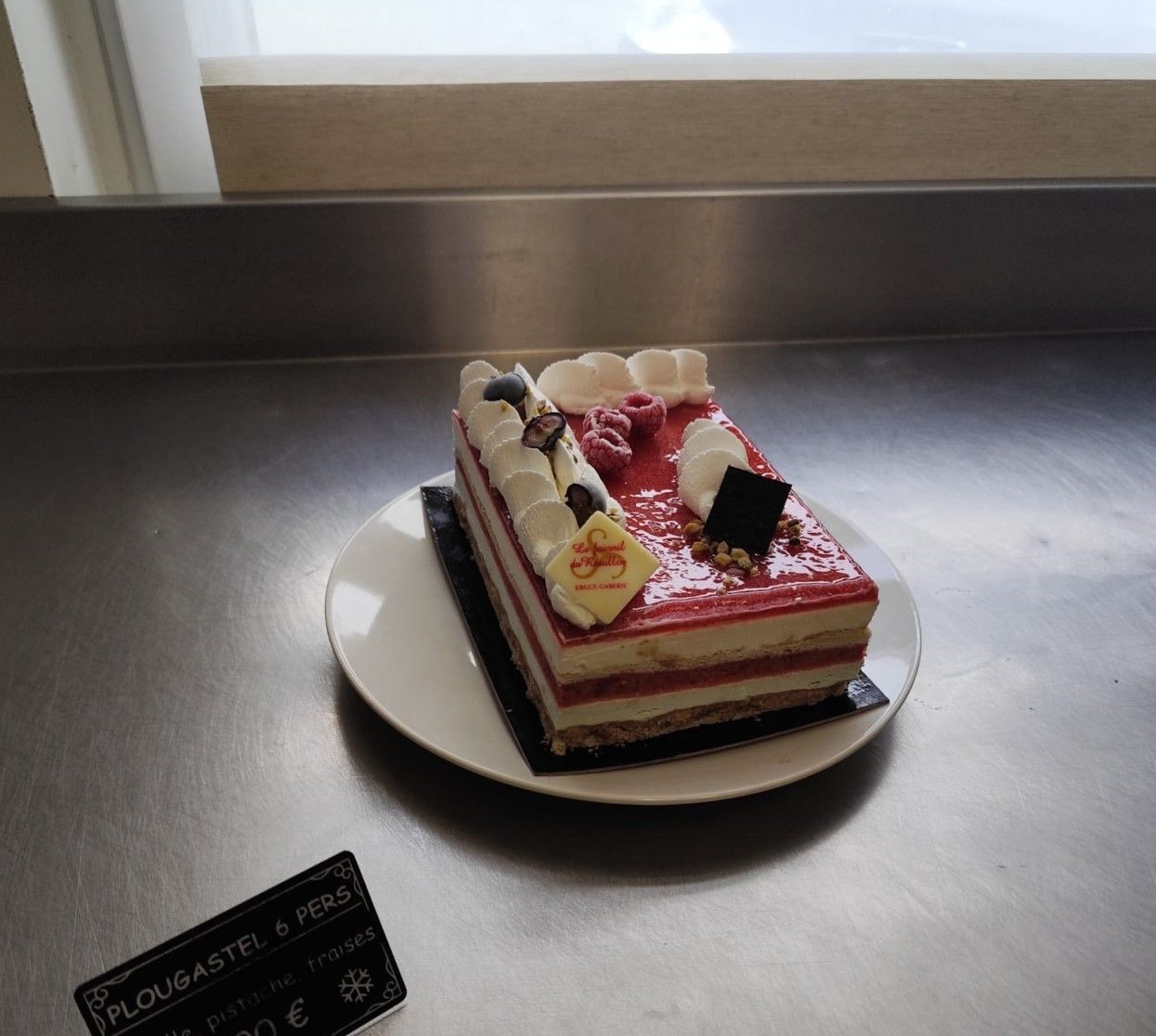 Petit gâteau rectangulaire garni de fruits rouges.
