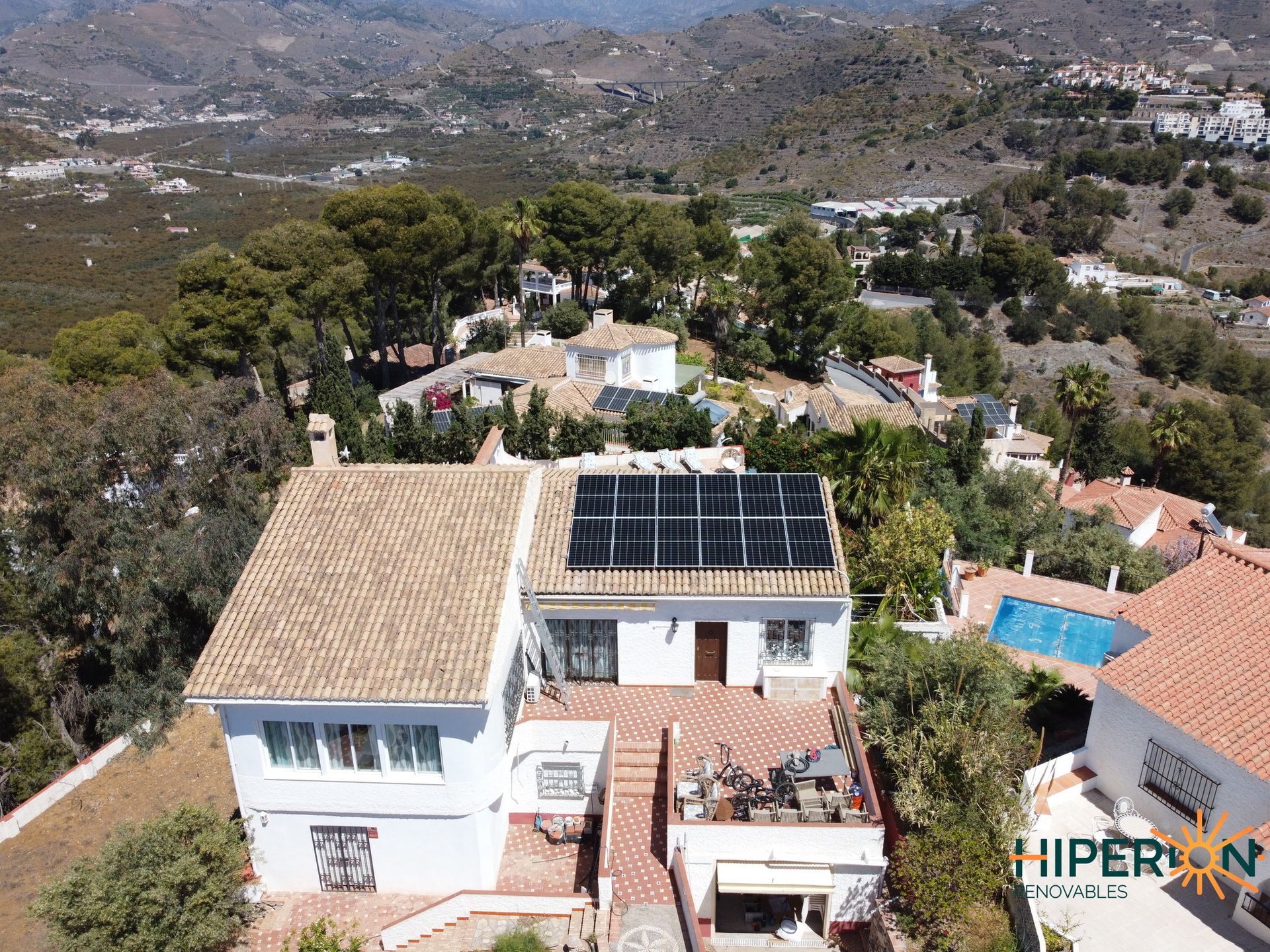 Una vista aérea de una casa con paneles solares en el techo.