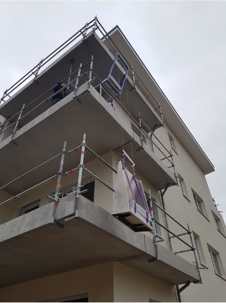 Gebäude im Bau; Gerüst umgibt ein mehrstöckiges Gebäude mit Balkonen; bedeckter Himmel.