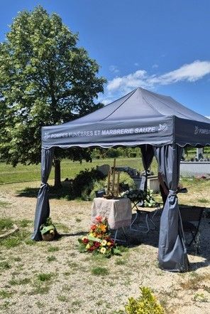 Deux personnes en costume sombre transportent un cercueil en bois à travers une porte