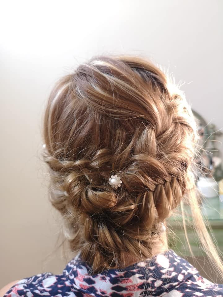 Recogido trenzado con pequeño accesorio de flor para el pelo.
