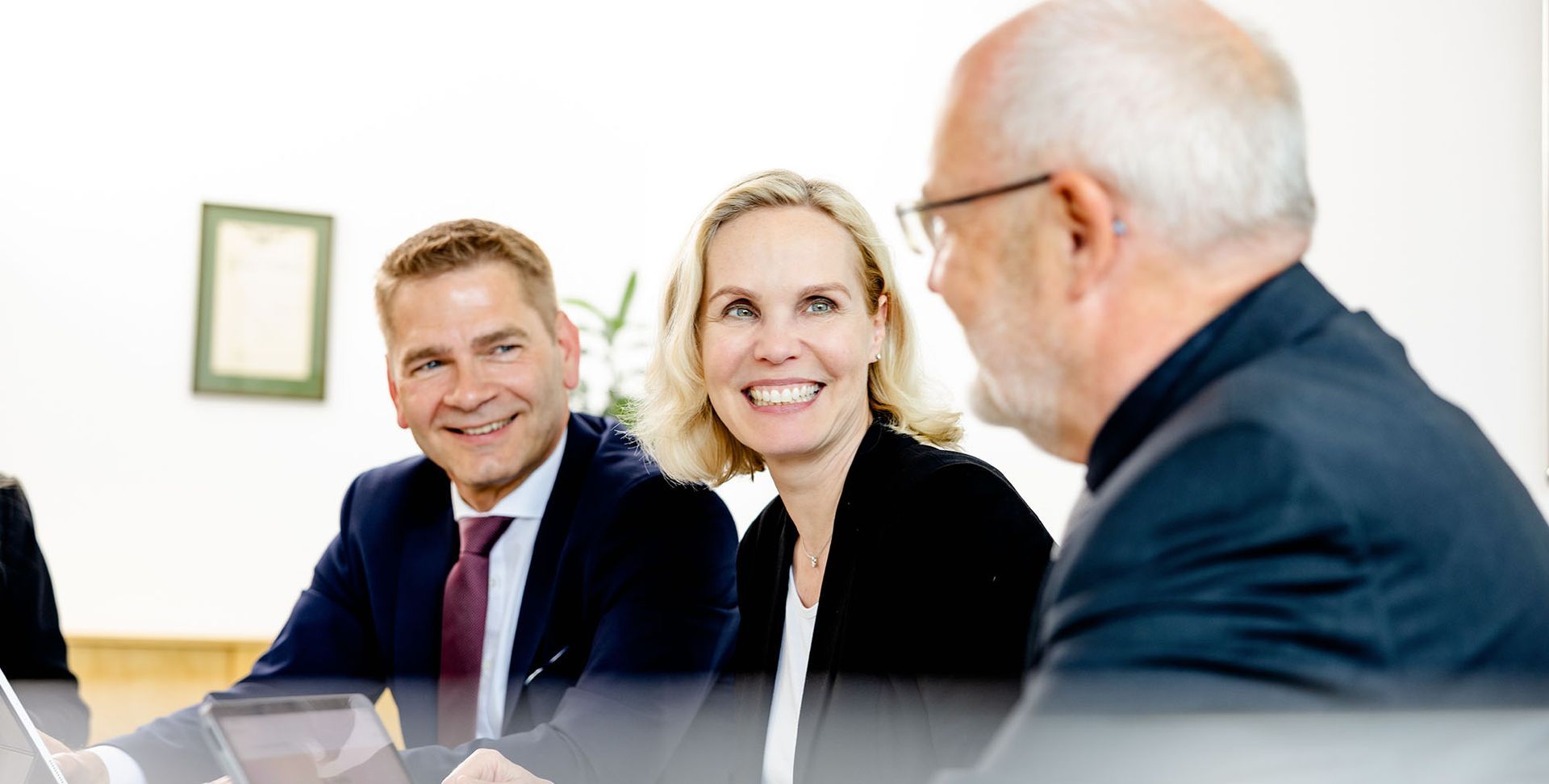 Eine Gruppe von Leuten sitzt an einem Tisch und hält eine Besprechung ab.