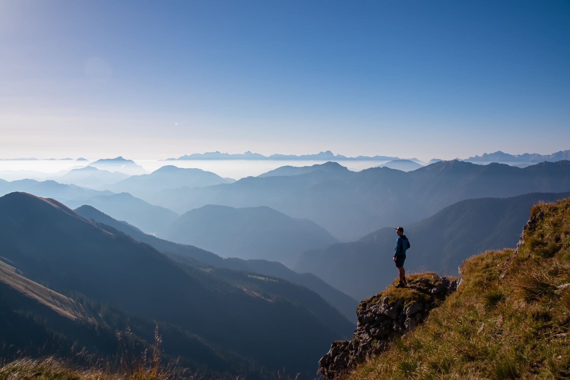 Eine Person steht auf einem Berggipfel und blickt über ein weites Tal – symbolisch für die Klarheit und Stärke, die durch Psychotherapie in Oldenburg erreicht werden kann.