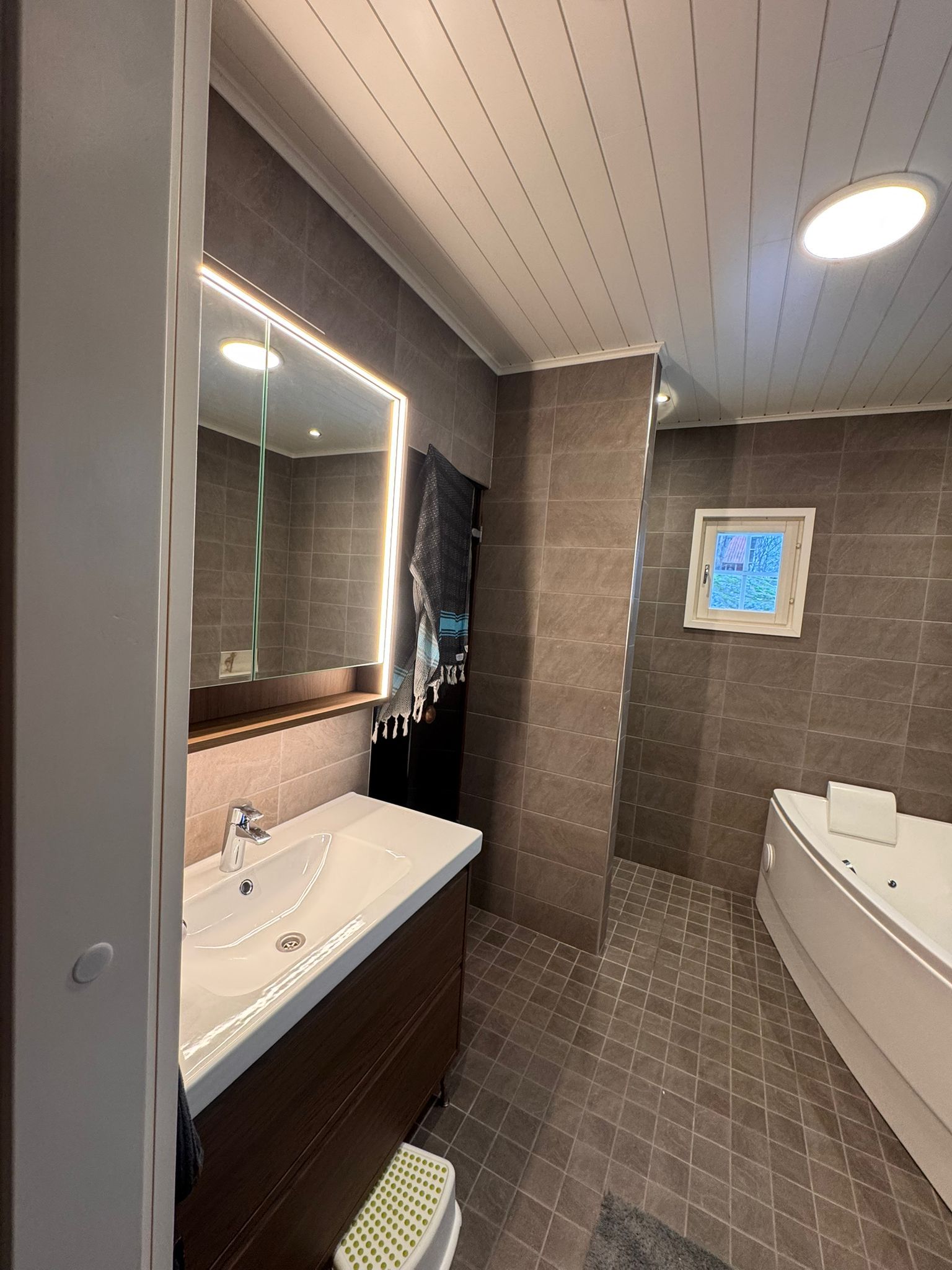 Moderni kylpyhuoneremontti Turussa, jossa käytetty suuria harmaita laattoja ja linjakaivoa