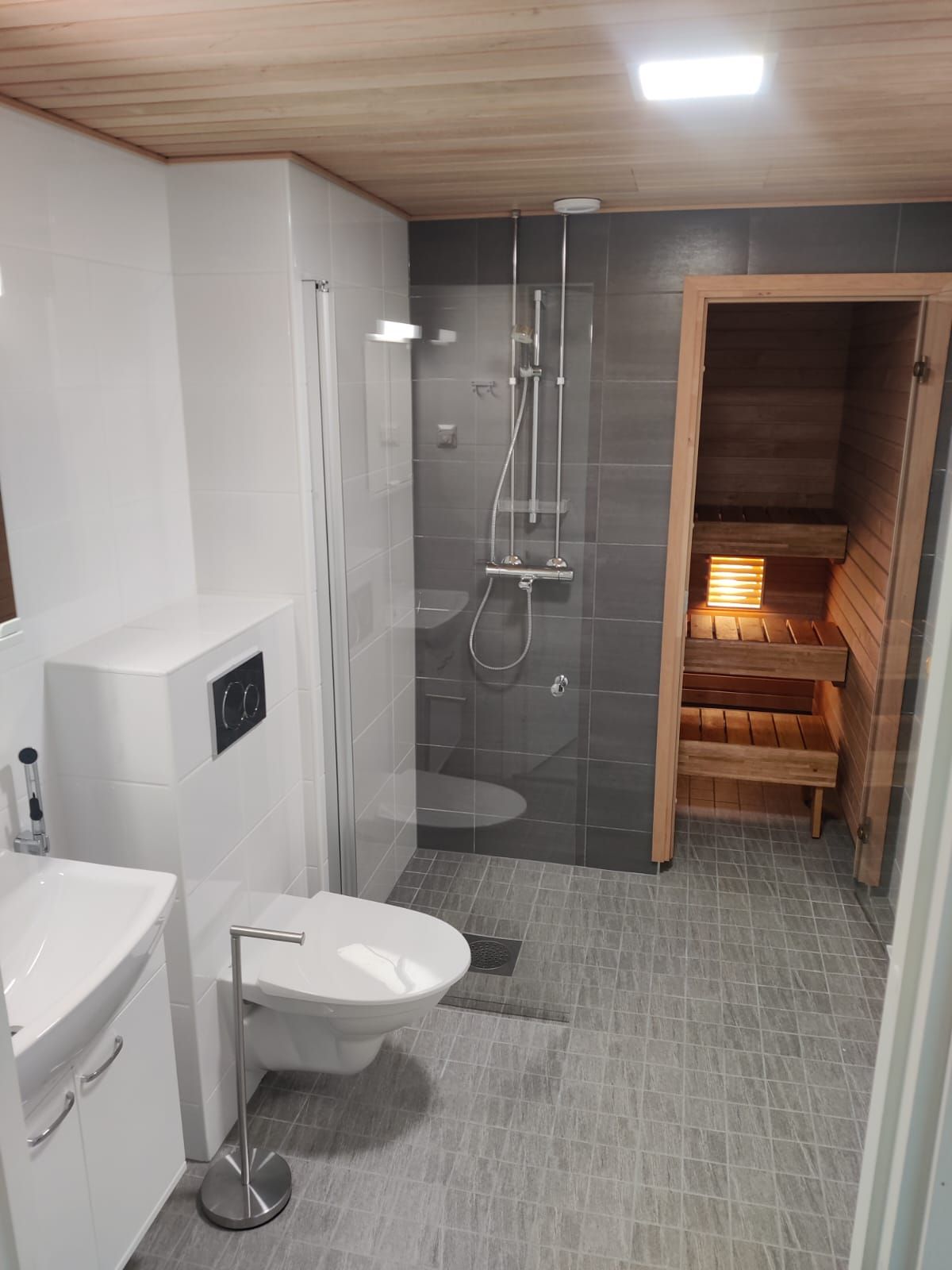 Uusi sauna ja lasiseinä asennettuna osana kokonaisvaltaista kylpyhuonesaneerausta.