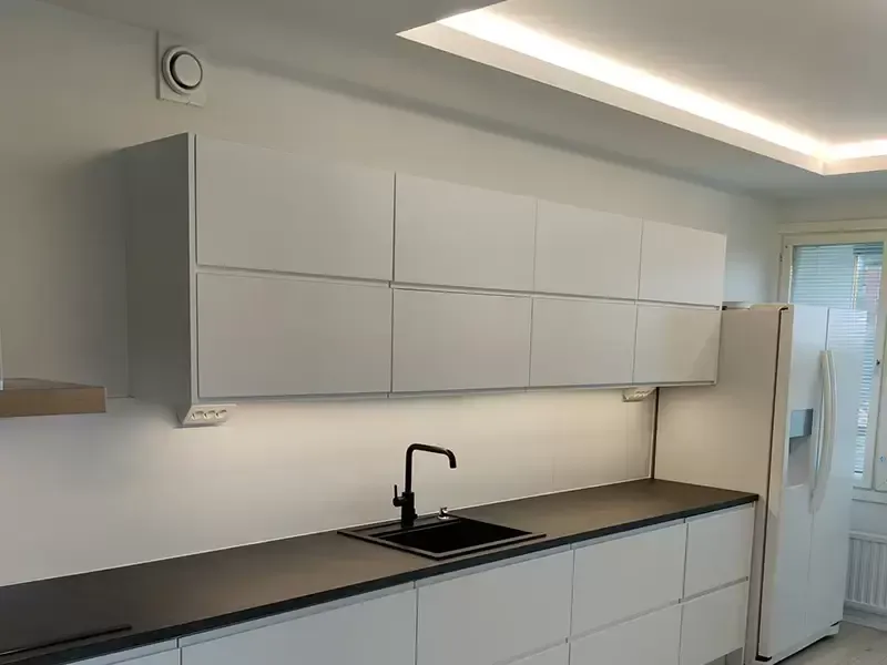 Keittiösaareke ja tyylikäs valaistus asennettuna osana laajempaa huoneistoremonttia.