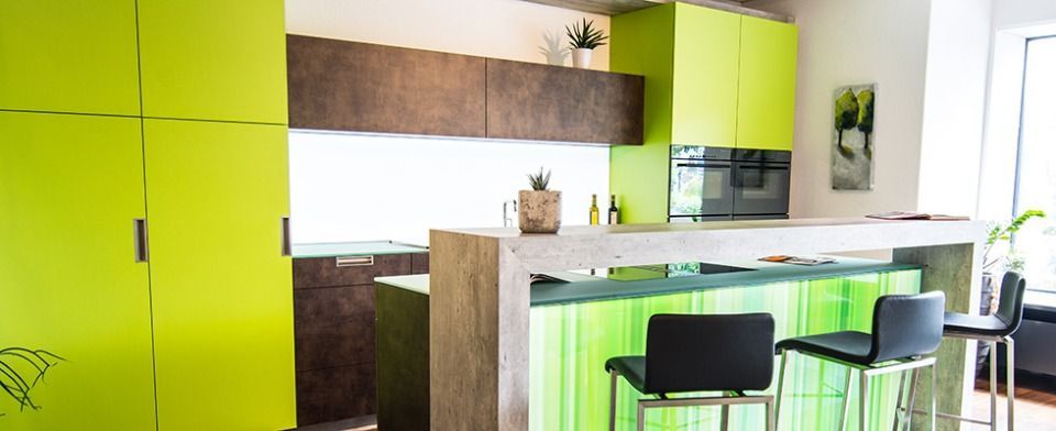 Eine Küche mit grünen Schränken und einer grünen Arbeitsplatte.