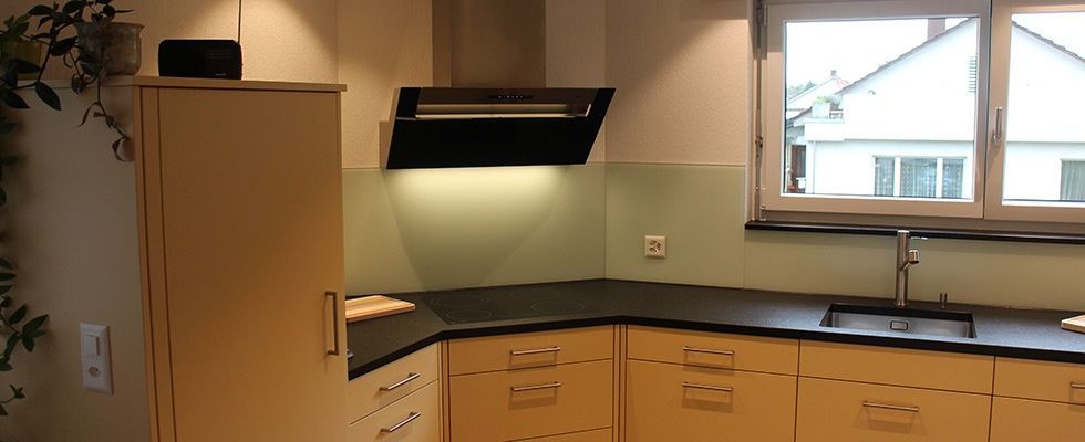 Eine Küche mit Holzschränken, einer Spüle und einem Fenster.