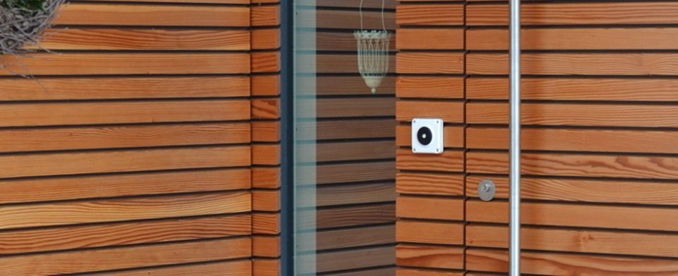 Eine Nahaufnahme einer Holzwand mit einer Glastür.