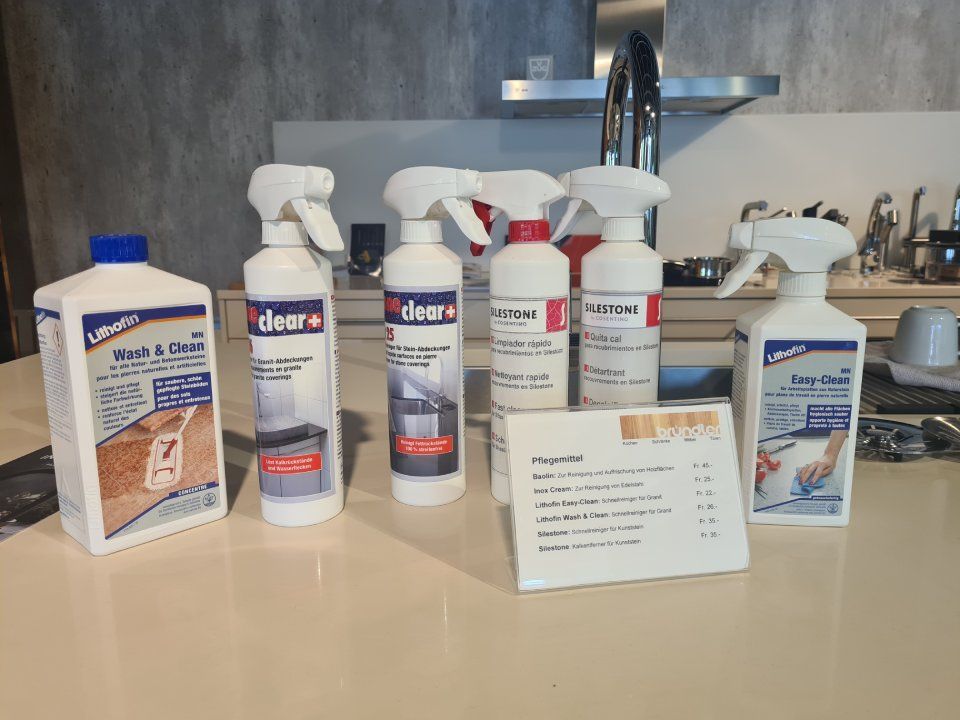 Mehrere Sprühflaschen stehen auf einer Küchentheke.