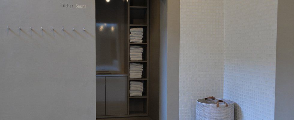 Ein Zimmer mit einem Regal voller Handtücher und einem Korb.