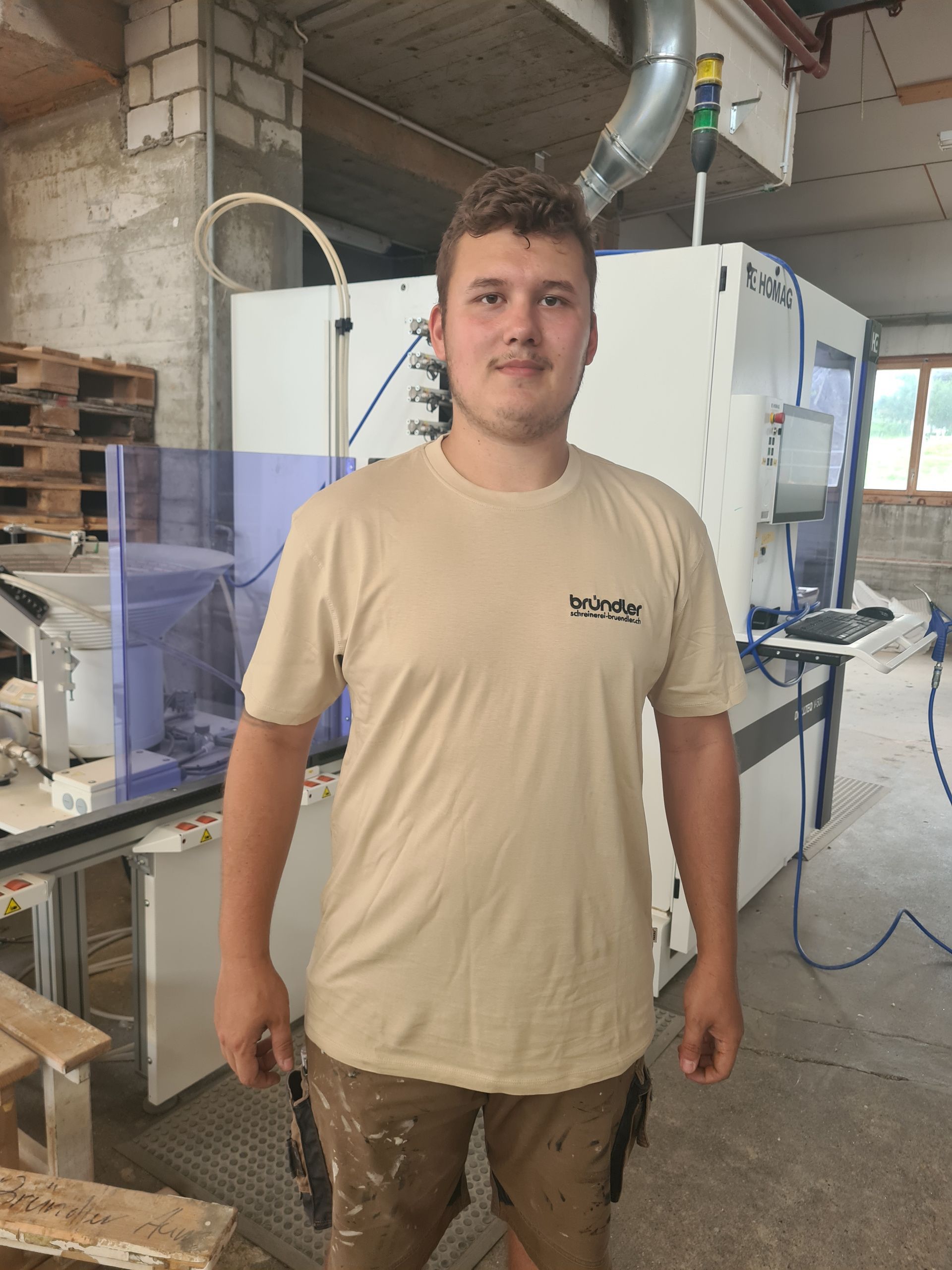 Ein Mann mit Brille und weißem Hemd lächelt in die Kamera.