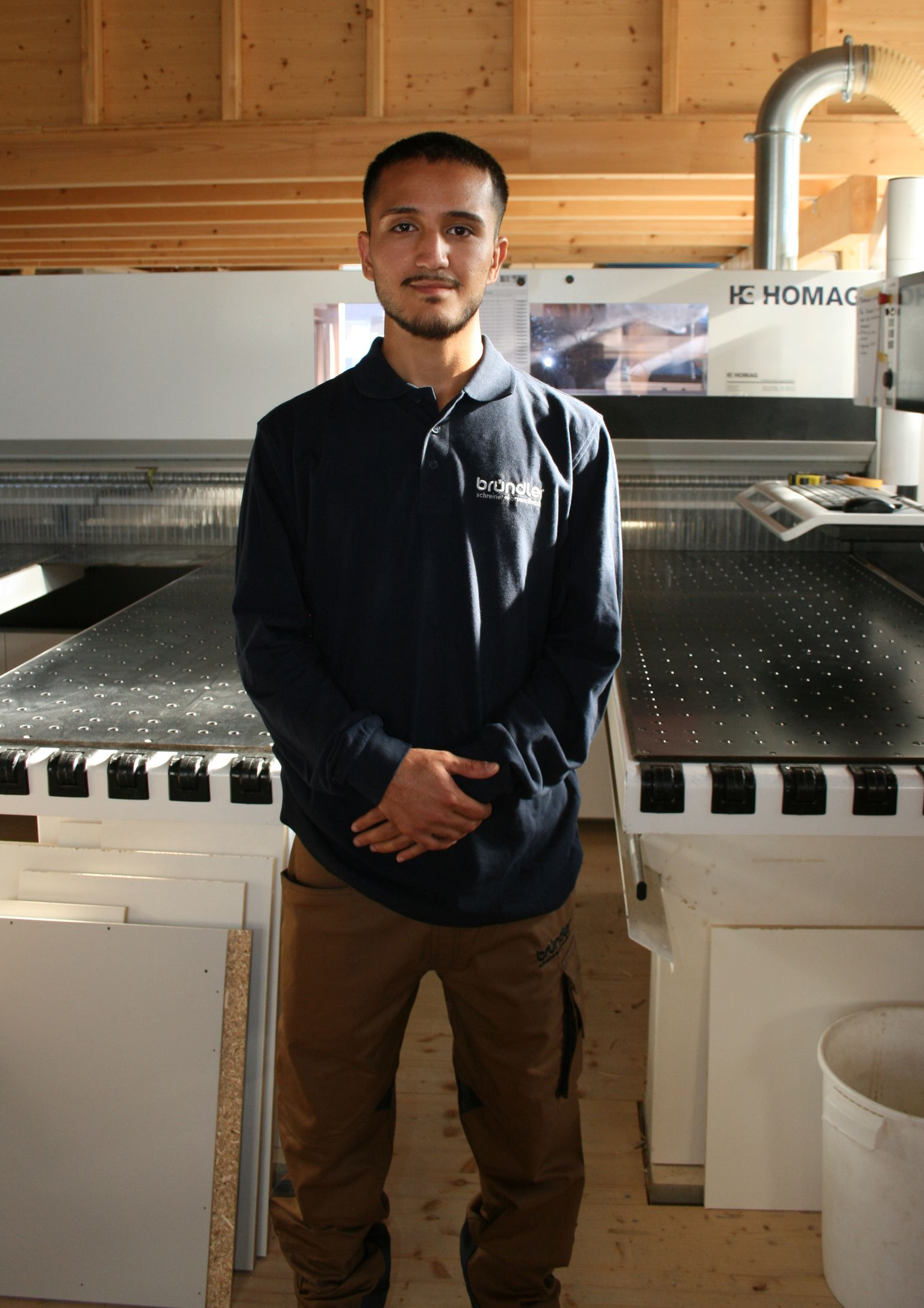 Ein Mann mit Brille und weißem Hemd lächelt in die Kamera.