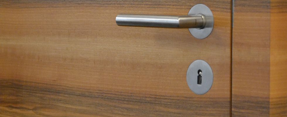 Eine Frau drückt einen Stoppknopf in einem Aufzug.