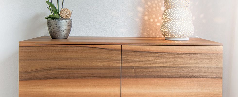 Ein Bett mit einer blauen Bettdecke und einem Nachttisch in einem Schlafzimmer.