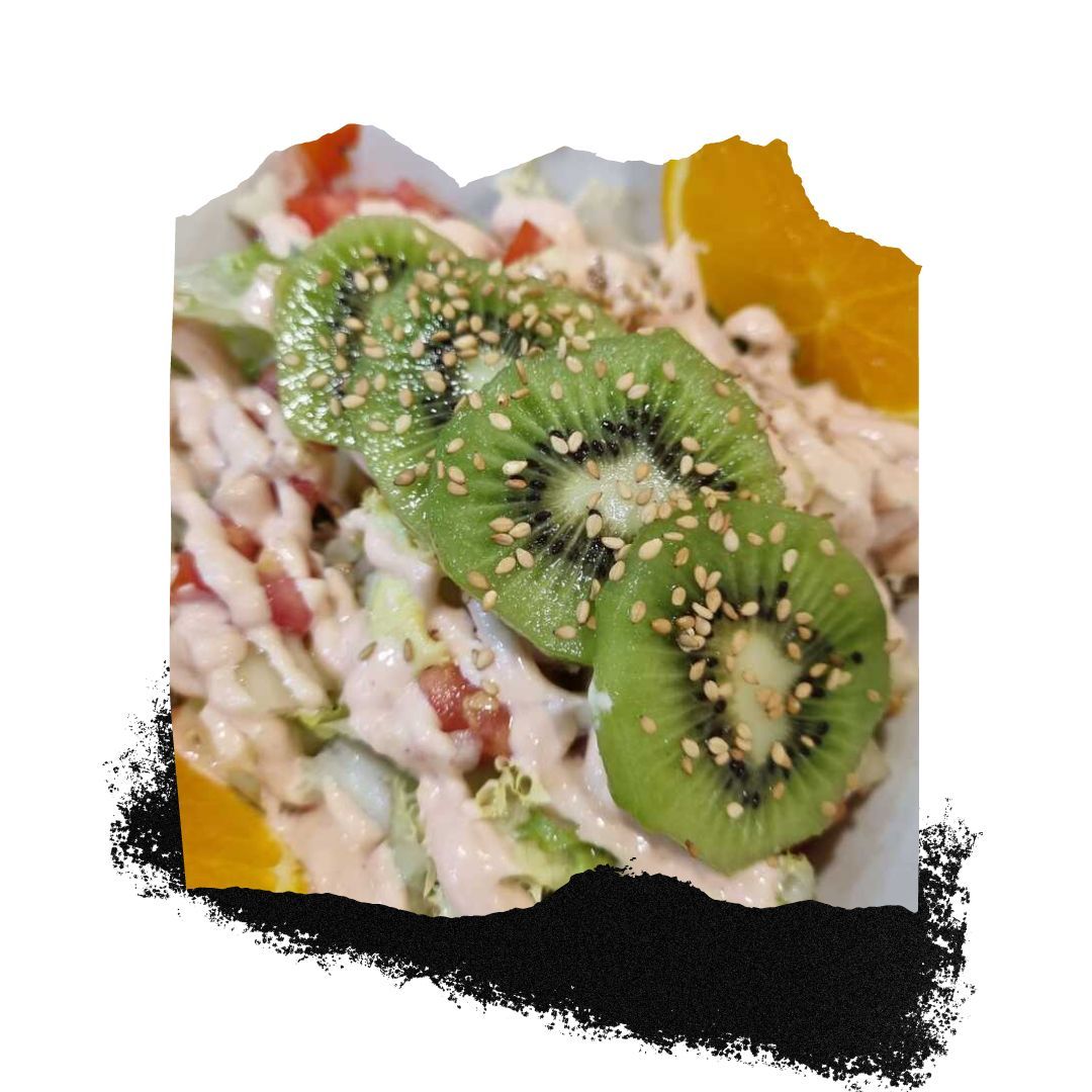 Una ensalada con rodajas de kiwi y semillas de sésamo encima.