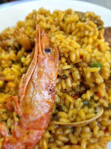 Un primer plano de un plato de comida con camarones y arroz.