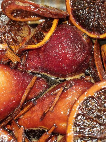 Un primer plano de un plato de comida con rodajas de naranja y ramas de canela.