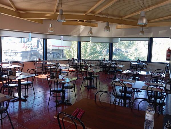 Un restaurante con mesas y sillas y un gran ventanal.