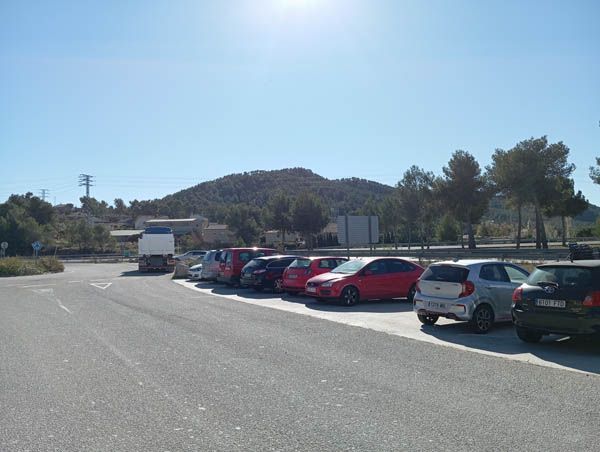 Hay muchos coches aparcados al costado de la carretera.