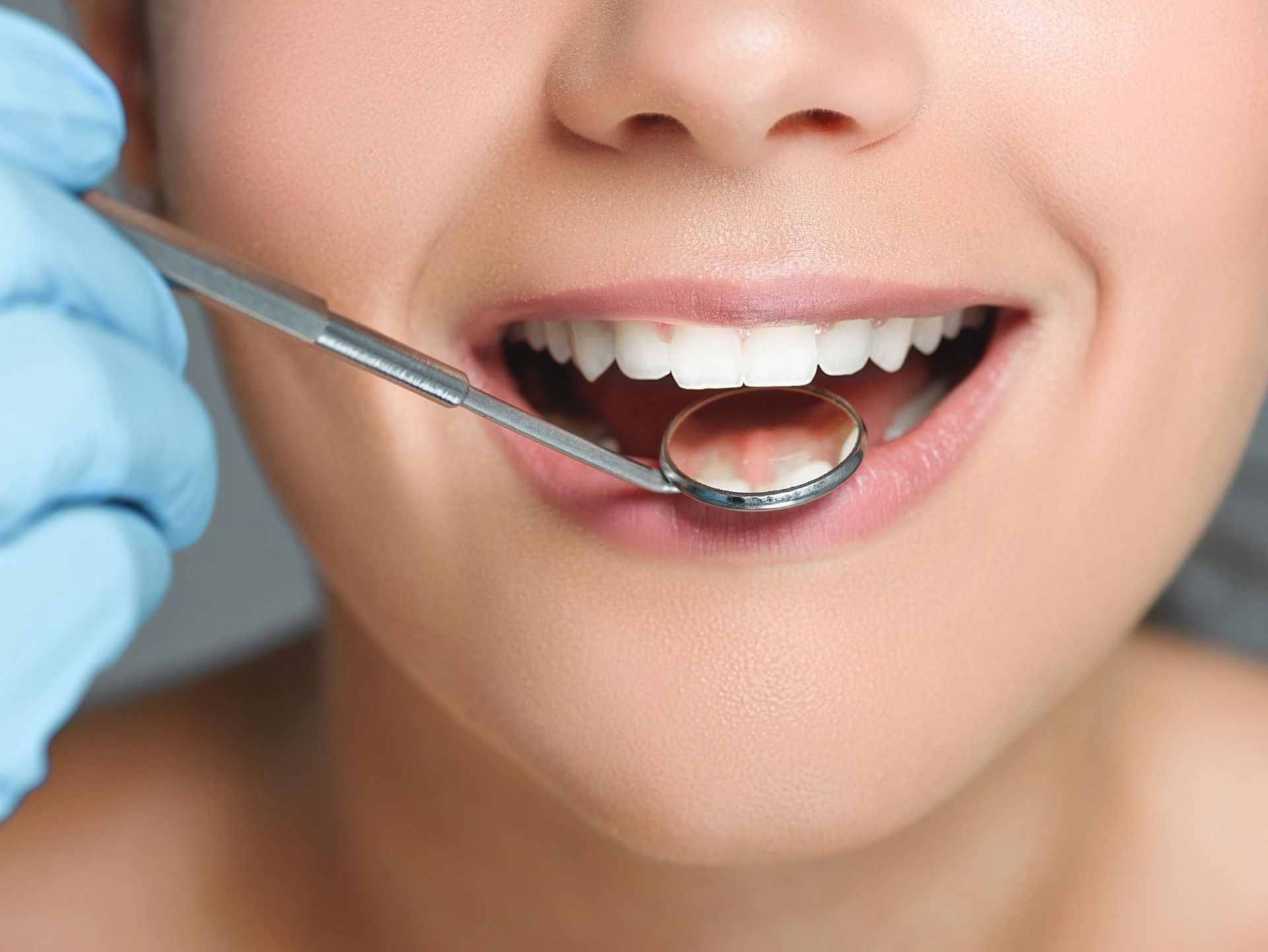Una mujer está siendo examinada por un dentista.