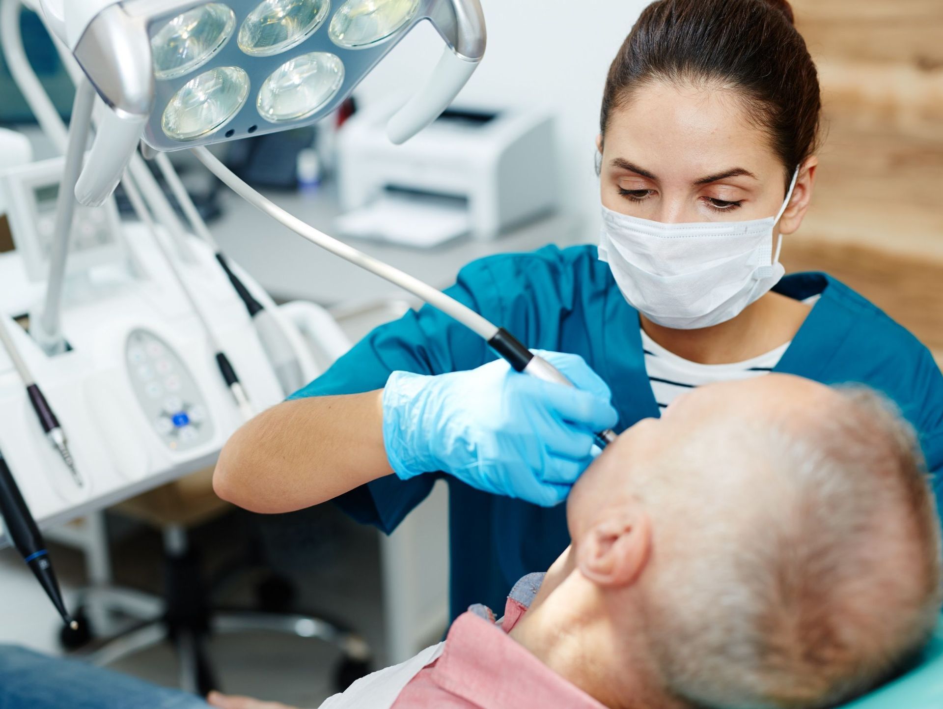 Una dentista examina los dientes de un hombre en un consultorio dental.