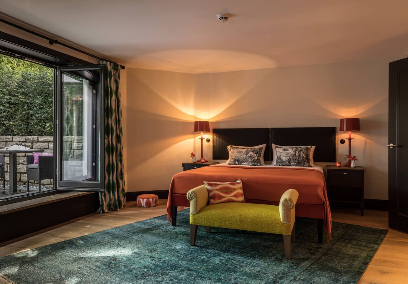 Ein Schlafzimmer mit einem Kingsize-Bett und einer grünen Bank.