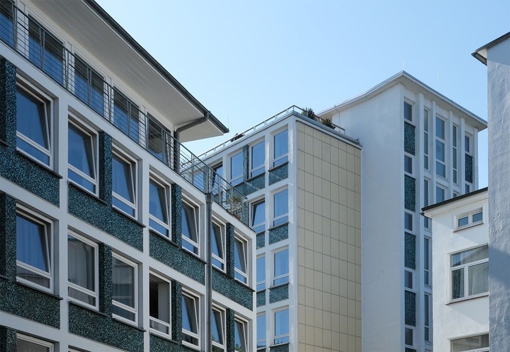 Ein Gebäude mit vielen Fenstern und einem blauen Himmel im Hintergrund