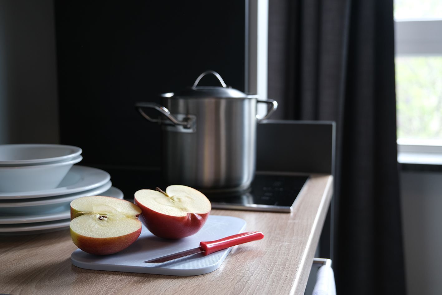 Auf einer Küchenzeile steht ein aufgeschnittener Apfel