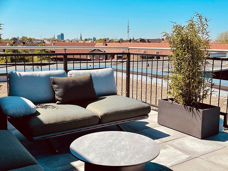 Ein Balkon mit Couch und Tisch mit Blick auf die Stadt