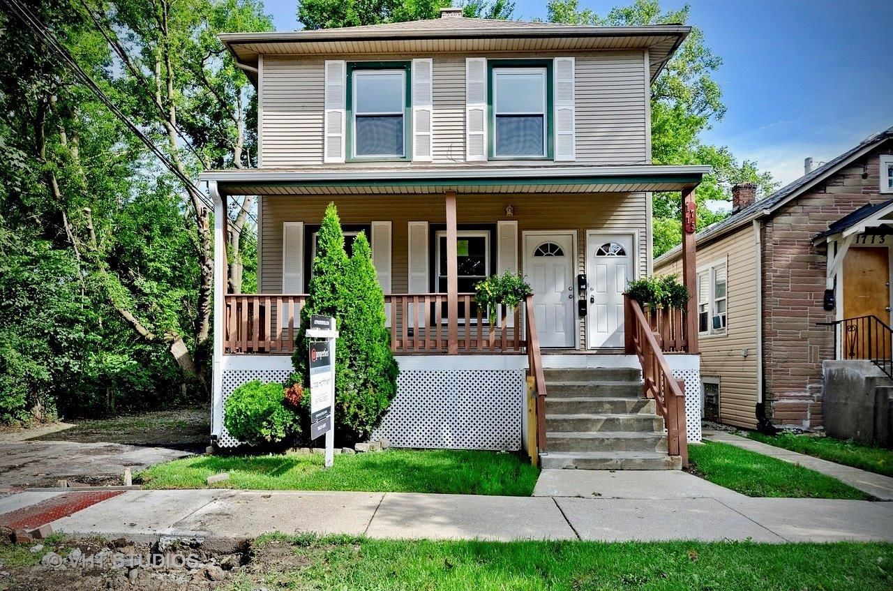 A house with a porch and stairs in front of it