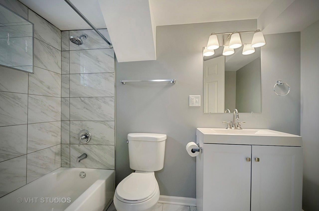 A bathroom with a toilet , sink and bathtub