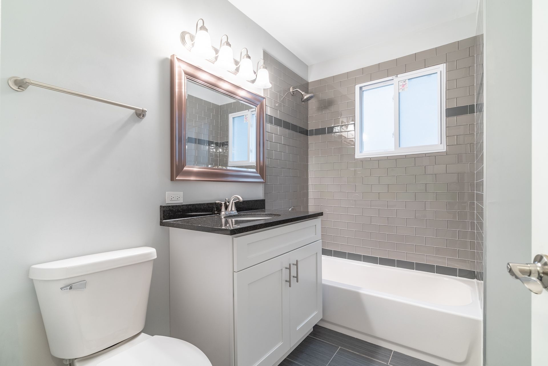 A bathroom with a toilet , sink , and bathtub.