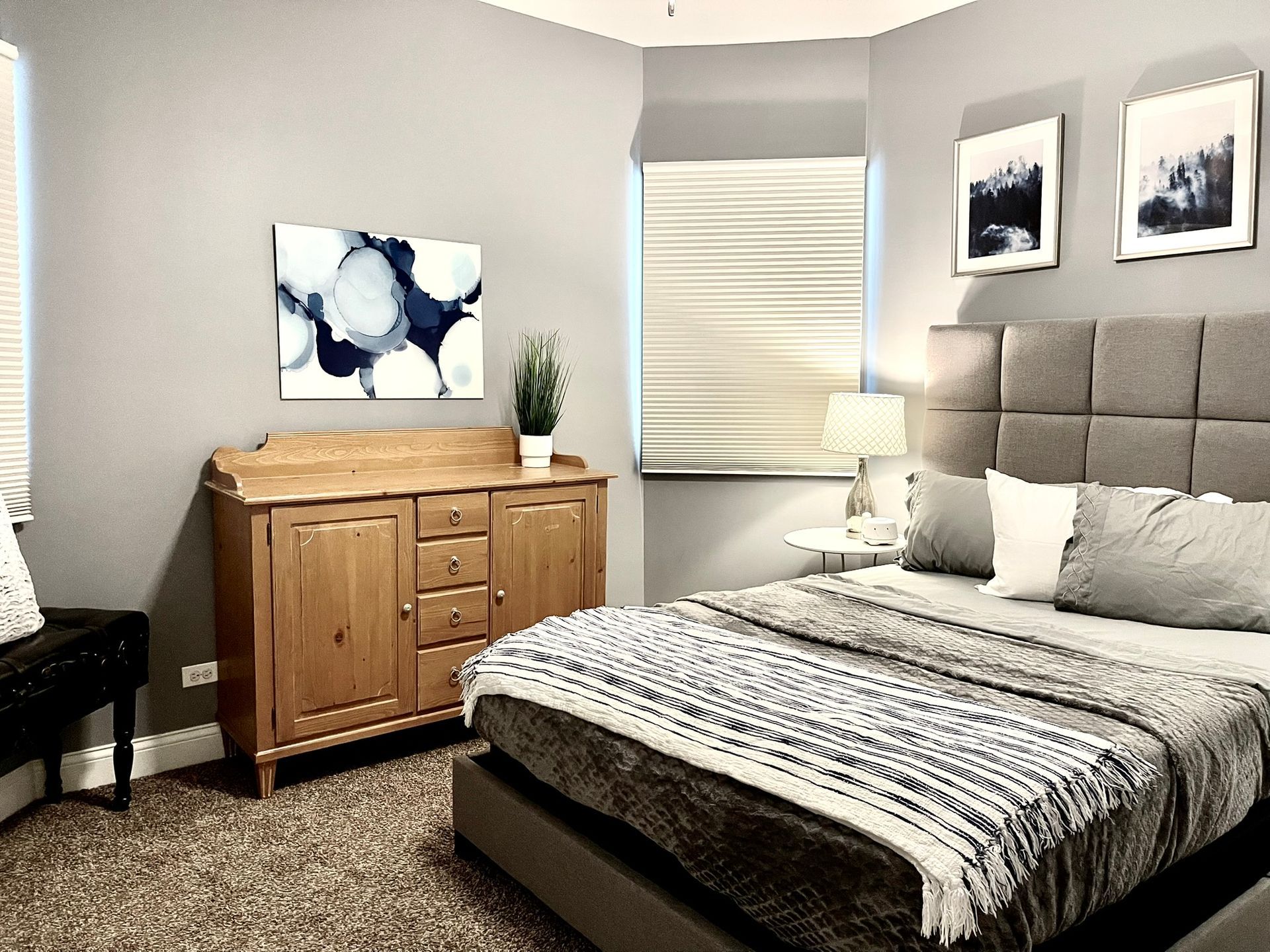 A bedroom with a bed , dresser , nightstand , and window.