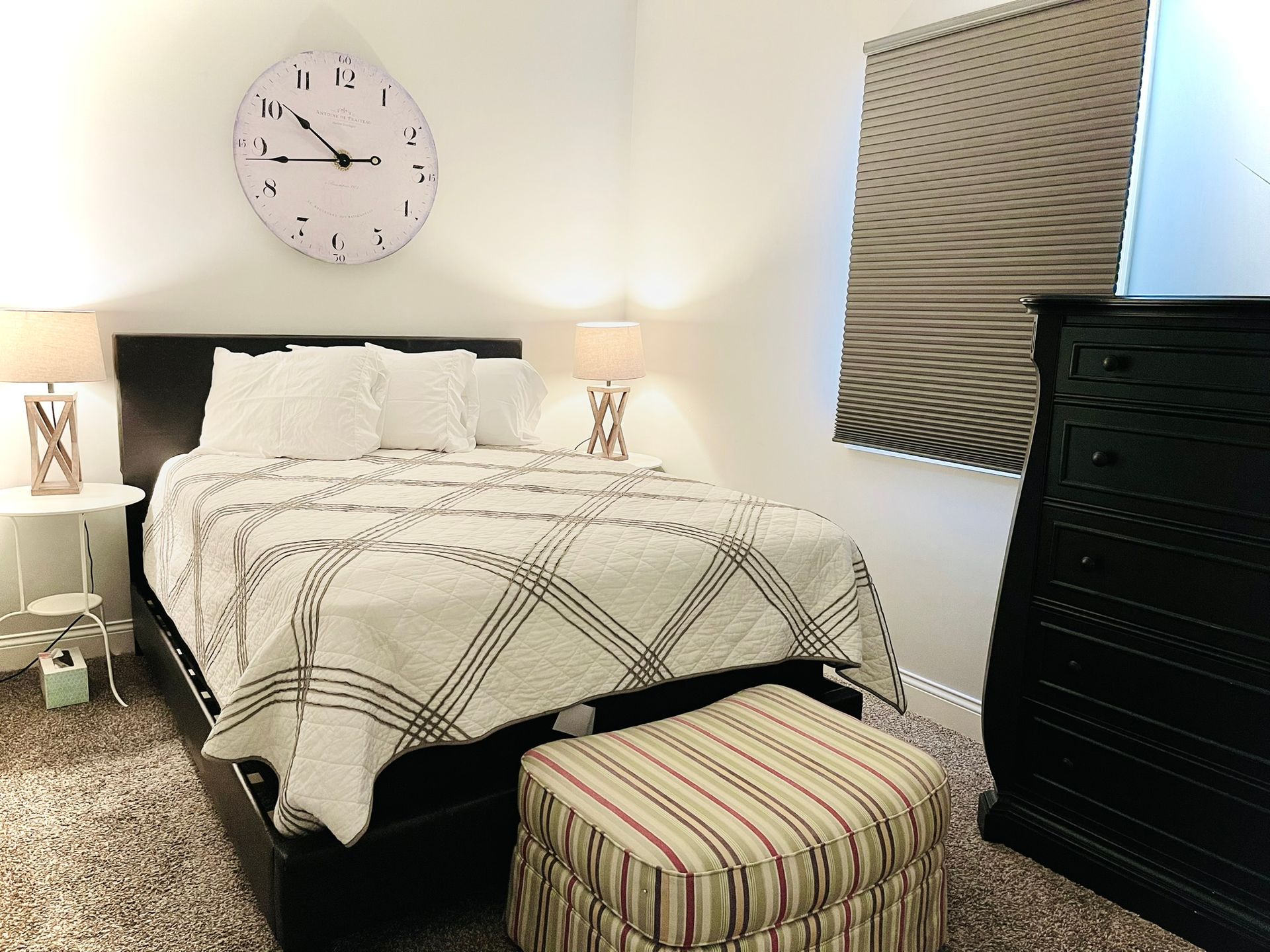 A bedroom with a bed and a clock on the wall