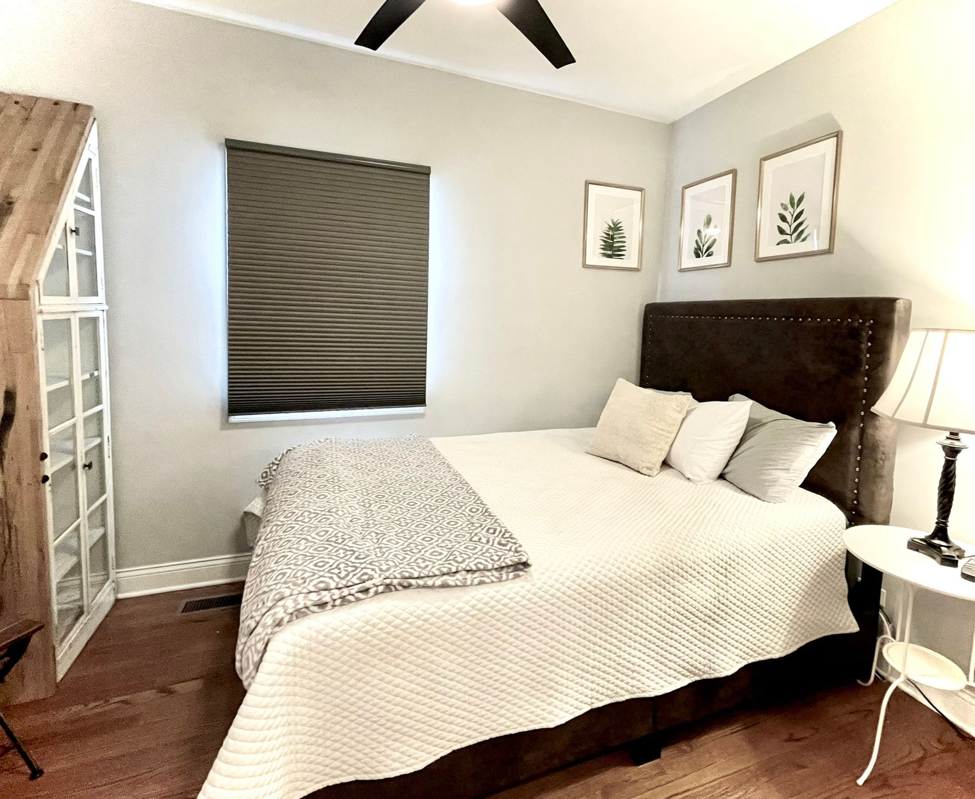 A bedroom with a bed and a ceiling fan