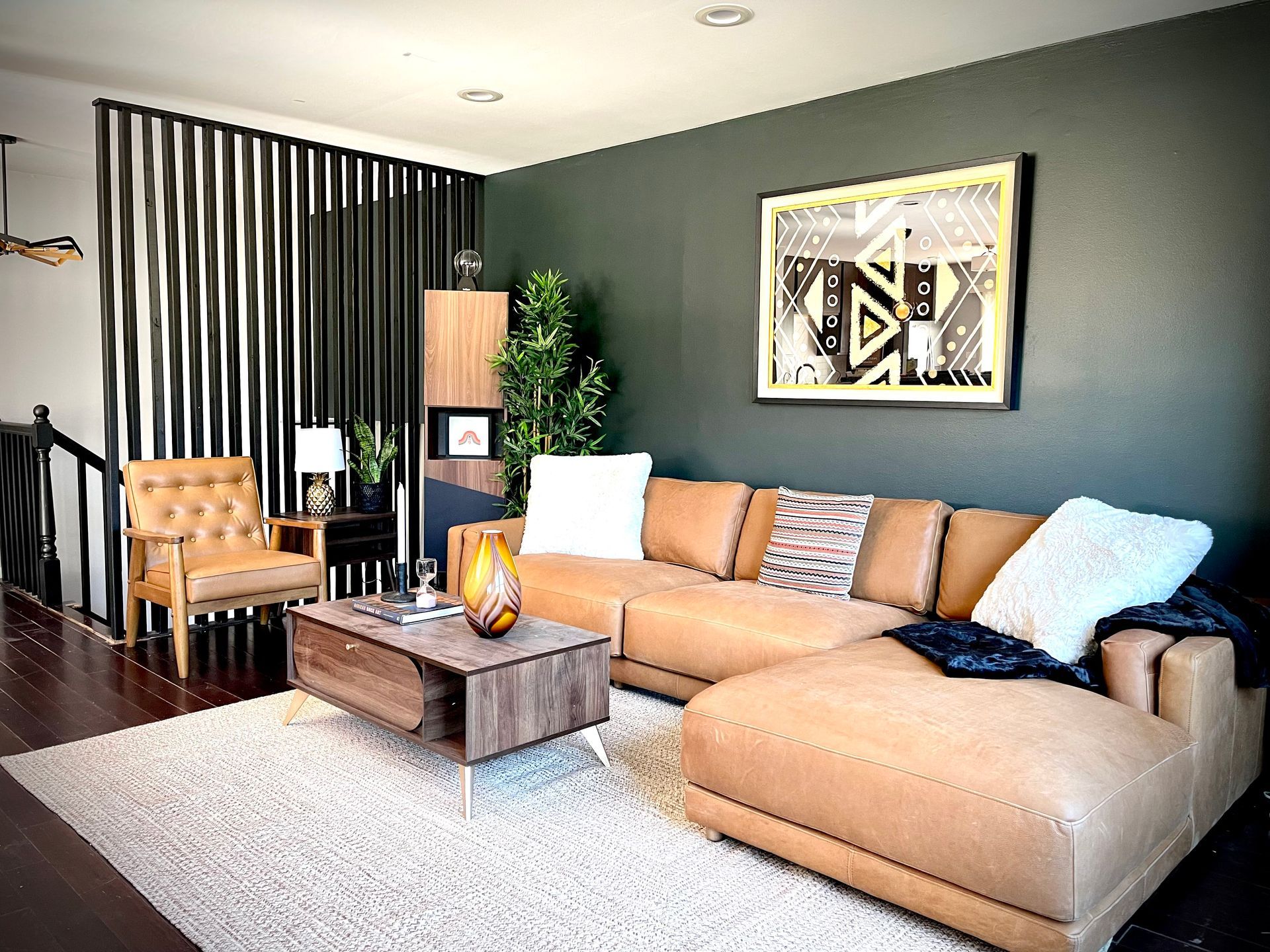 A living room with a couch , chair , coffee table and rug.