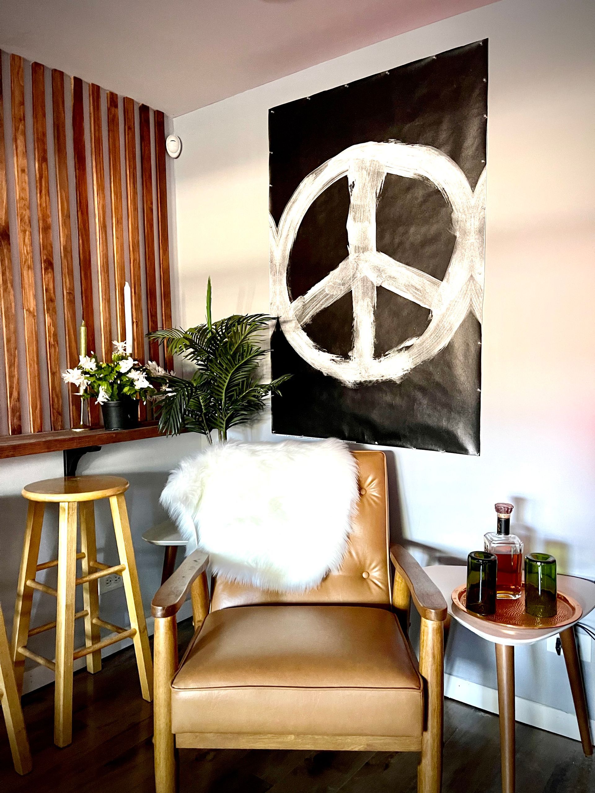 There is a peace sign on the wall above the chair.